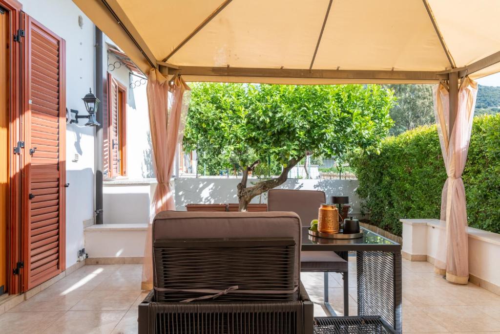 an outdoor patio with a table and a tree at Lime Calabria Apartment in Falerna Marina