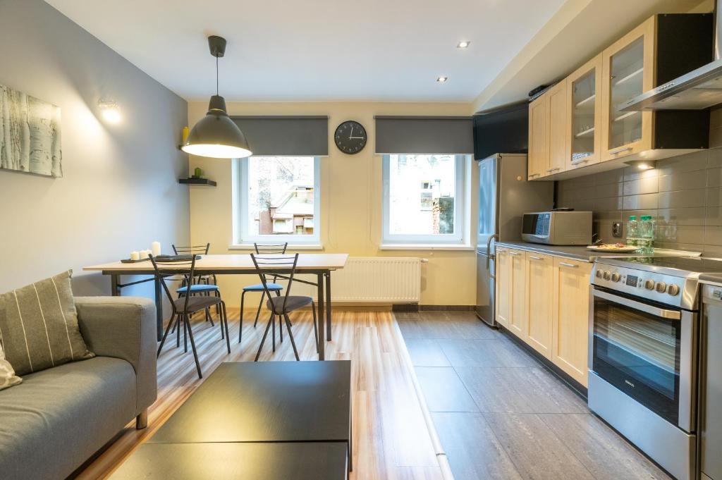 a kitchen and living room with a couch and a table at Katowice Central Apartment by BookingHost in Katowice