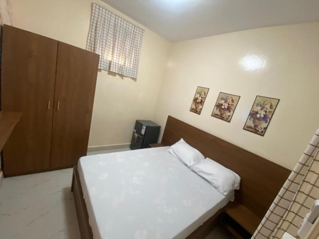 ein kleines Schlafzimmer mit einem Bett und einem Schrank in der Unterkunft Résidence Keur Mame Seye 3 in Dakar
