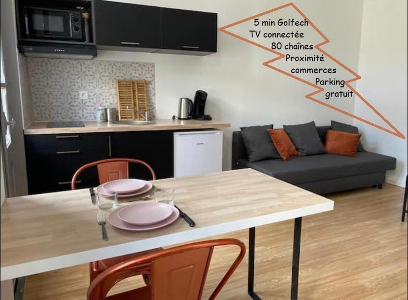 a living room with a table with chairs and a couch at V2 Studio avec balcon, plein centre - 5 min Golfech in Valence-dʼAgen