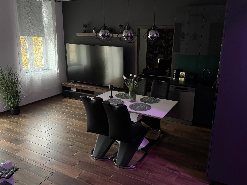 a dining room with a table and chairs and a kitchen at NewPlace Luxury Apartment in Sátoraljaújhely