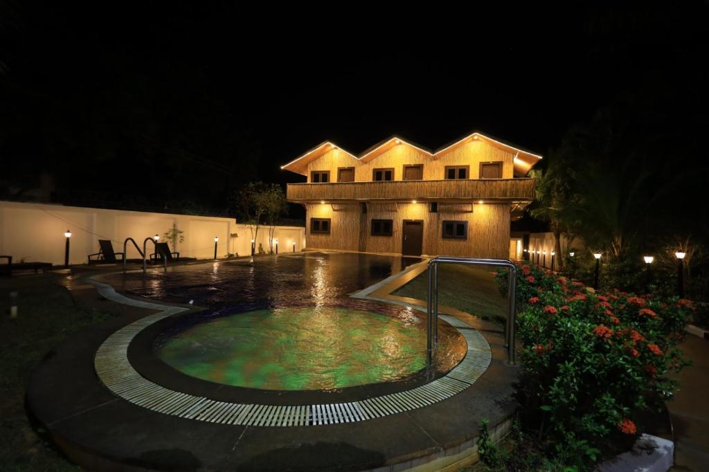un edificio con piscina por la noche en The Exotic Aura Resort, en Pondicherry