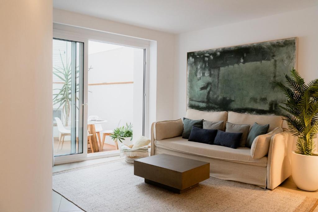 a living room with a couch and a painting on the wall at Gaia Apartments & Lofts Cadaqués in Cadaqués