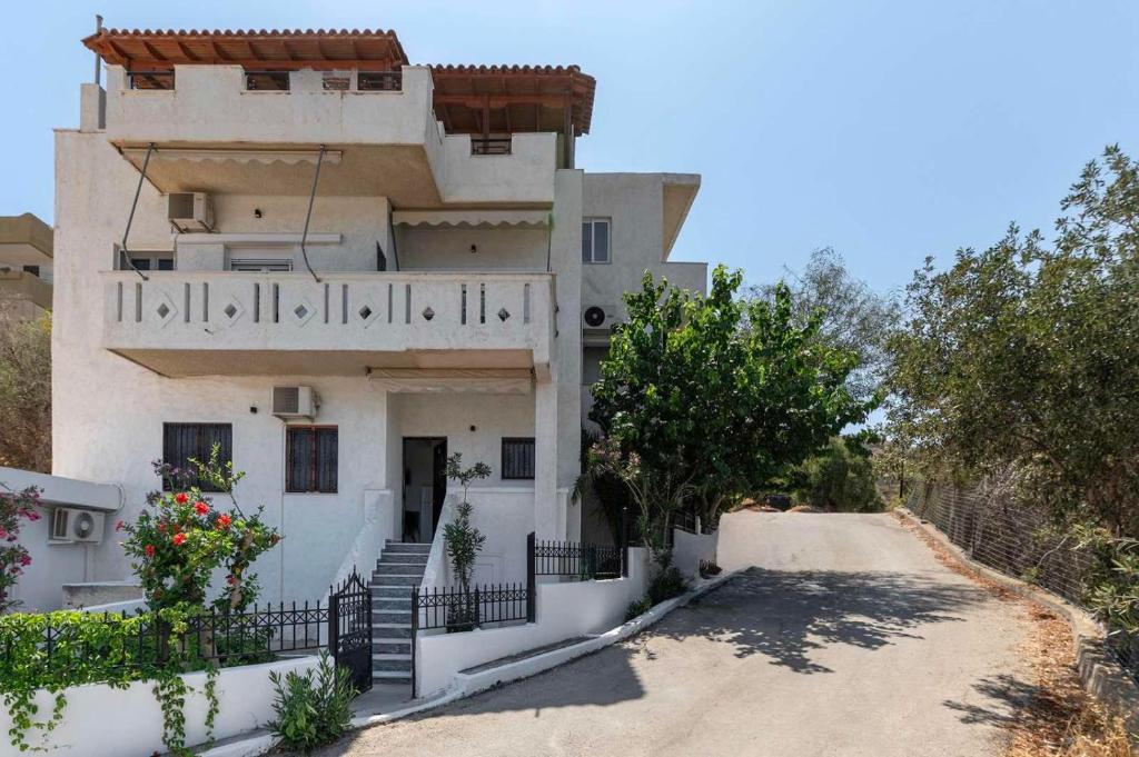 a large white house with stairs and flowers at Mirtos4seasons Harmony in Myrtos