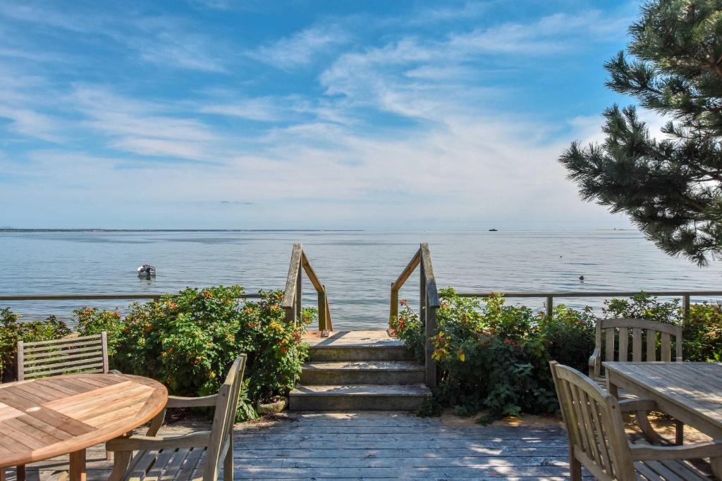 a stairway leading to the ocean with a table and chairs at Waterfront with Private Beach Stunning Views in Provincetown