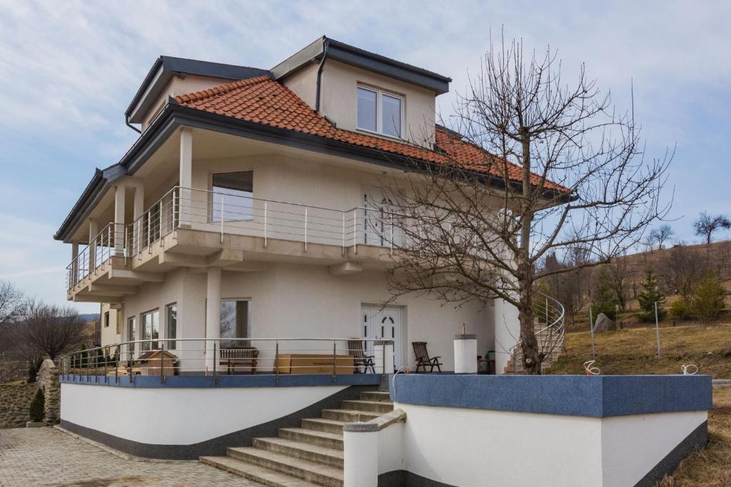 a house with a staircase in front of it at Villa Grande in Odorheiu Secuiesc