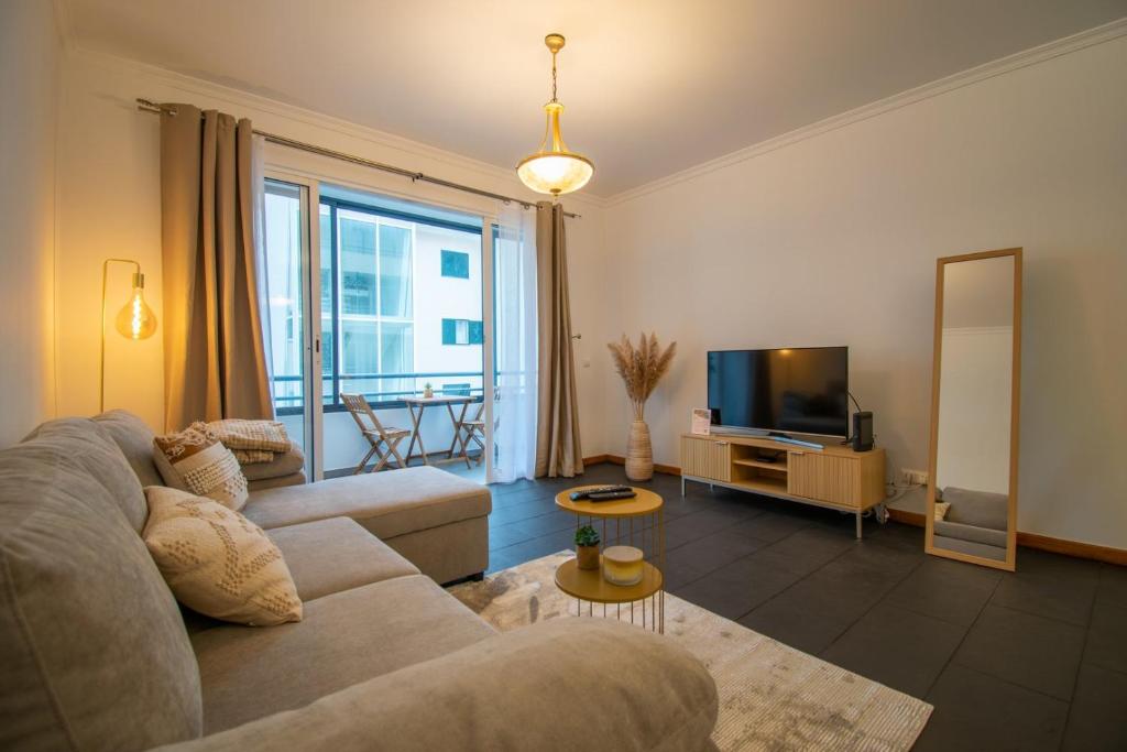 un salon avec un canapé et une télévision dans l'établissement GuestReady - Charming Apartment with Ocean Views, à Nogueira