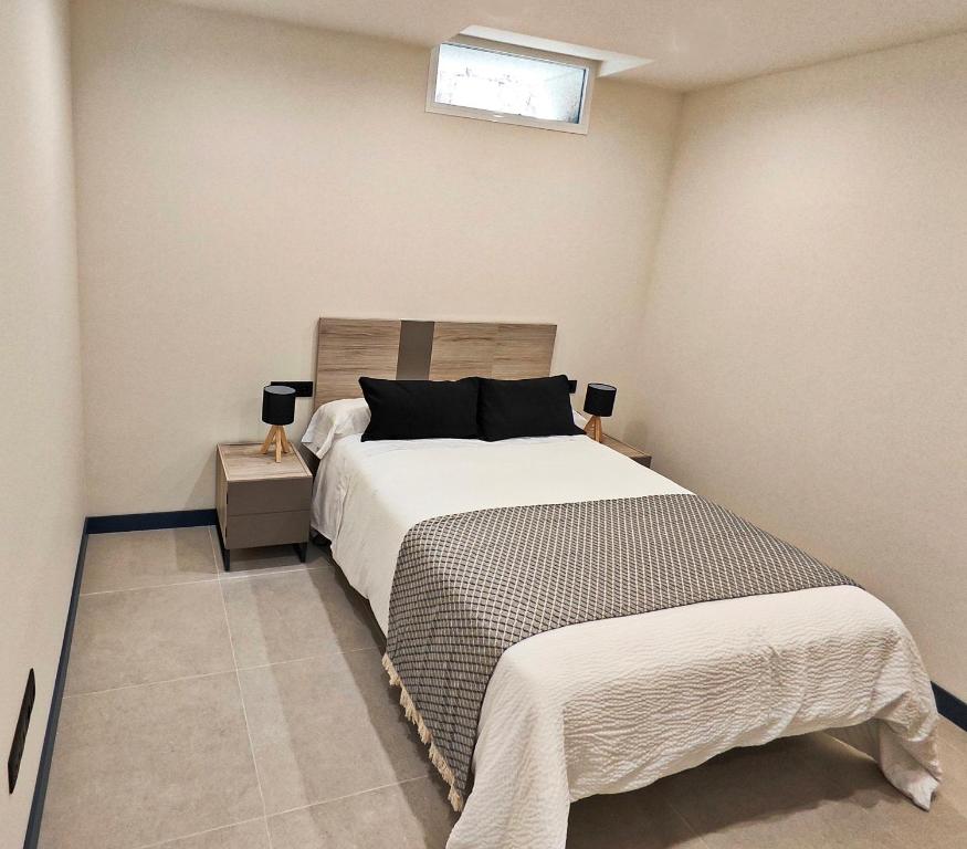 Vivienda Unifamiliar Ventana a la Clerecía في سلامنكا: غرفة نوم مع سرير ونافذة على الحائط