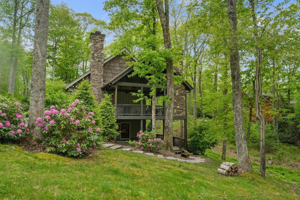 ein Steinhaus im Wald mit Blumen in der Unterkunft Sweet Retreat at Sweetgrass in Blowing Rock