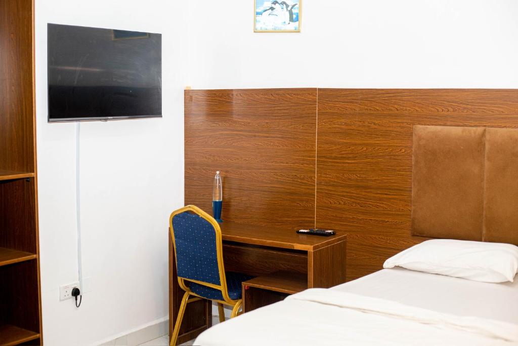 una camera da letto con una scrivania, un letto e una scrivania di Richmond Towne Home Apartmentt a Ibadan