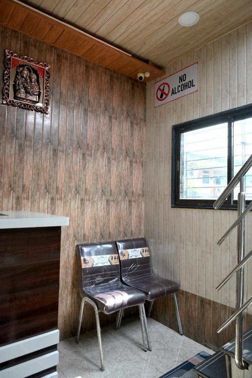 a chair in a room with a no alcohol sign at Hotel Bhagirath in Mumbai