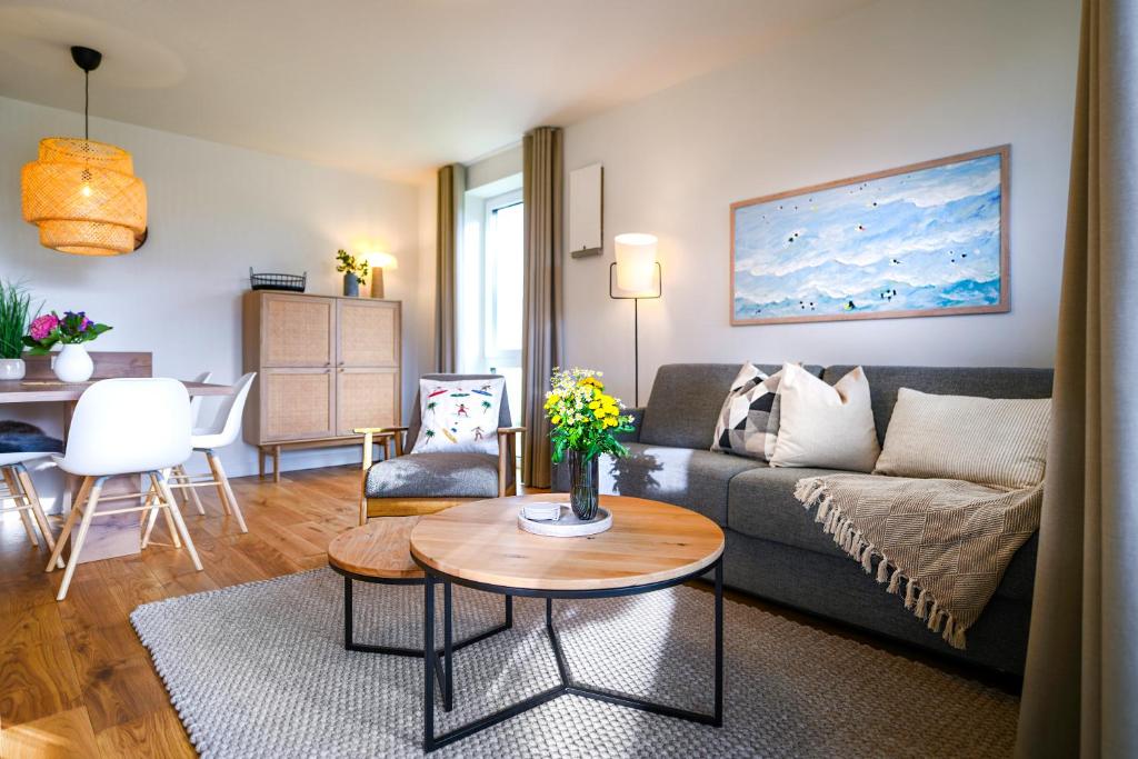 een woonkamer met een bank en een tafel bij Salzbrise - Balkon, Sauna, Strandnah, Familienfreundlich in Kellenhusen