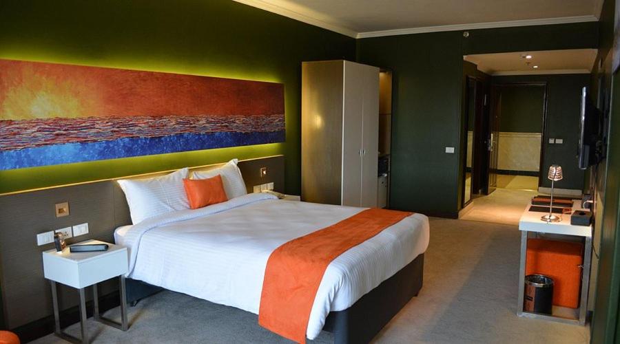 アスワンにあるNile Plaza Suitesの壁に絵が飾られた大きなベッドのある寝室