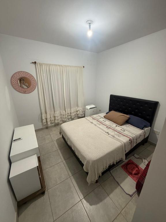 波萨达斯Casa Yvy Guazú的一间卧室，里面有一张大床和一张桌子。