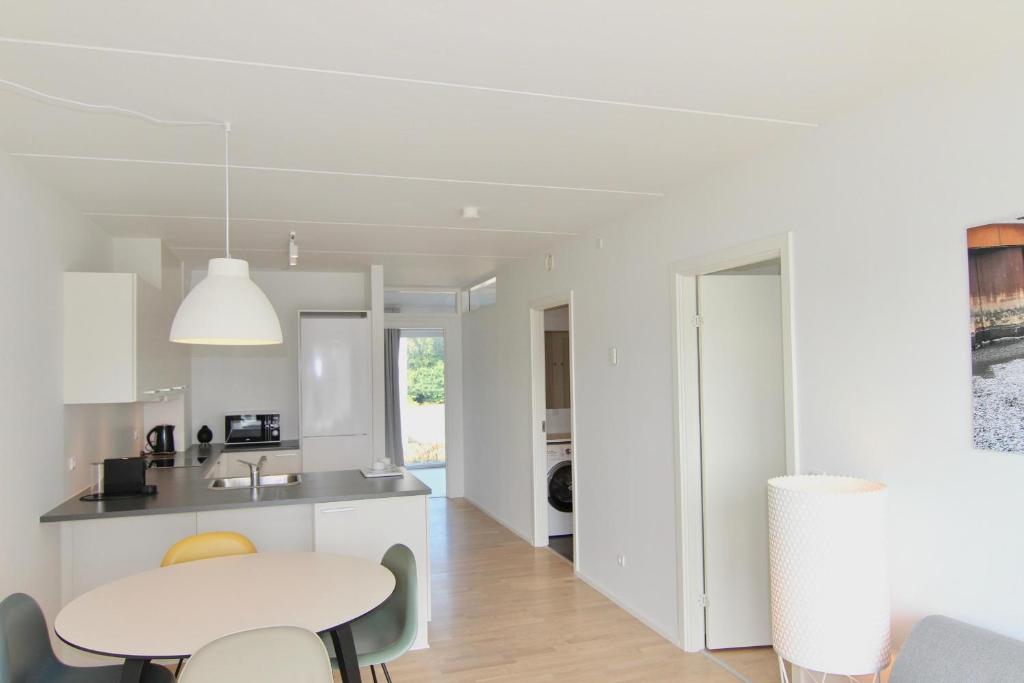 Una cocina y un comedor con mesa y sillas. en Beautiful 2-BR w a balcony by Odense Harbour - 125, en Odense