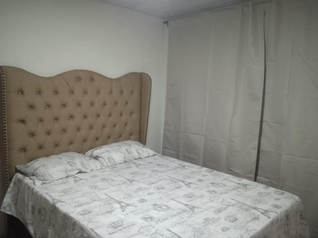 een slaapkamer met een bed met een witte sprei bij Balcones de la montaña in El Limón