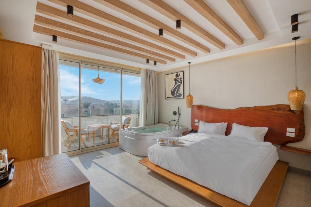 开罗ONE GATE Pyramids View INN的一间带床、浴缸和桌子的卧室