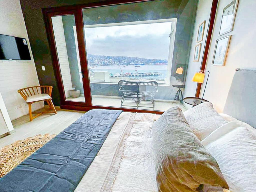 una camera da letto con un letto e una grande finestra di HOM I Duplex en Mejor Vista de Valparaiso y Parking a Valparaíso