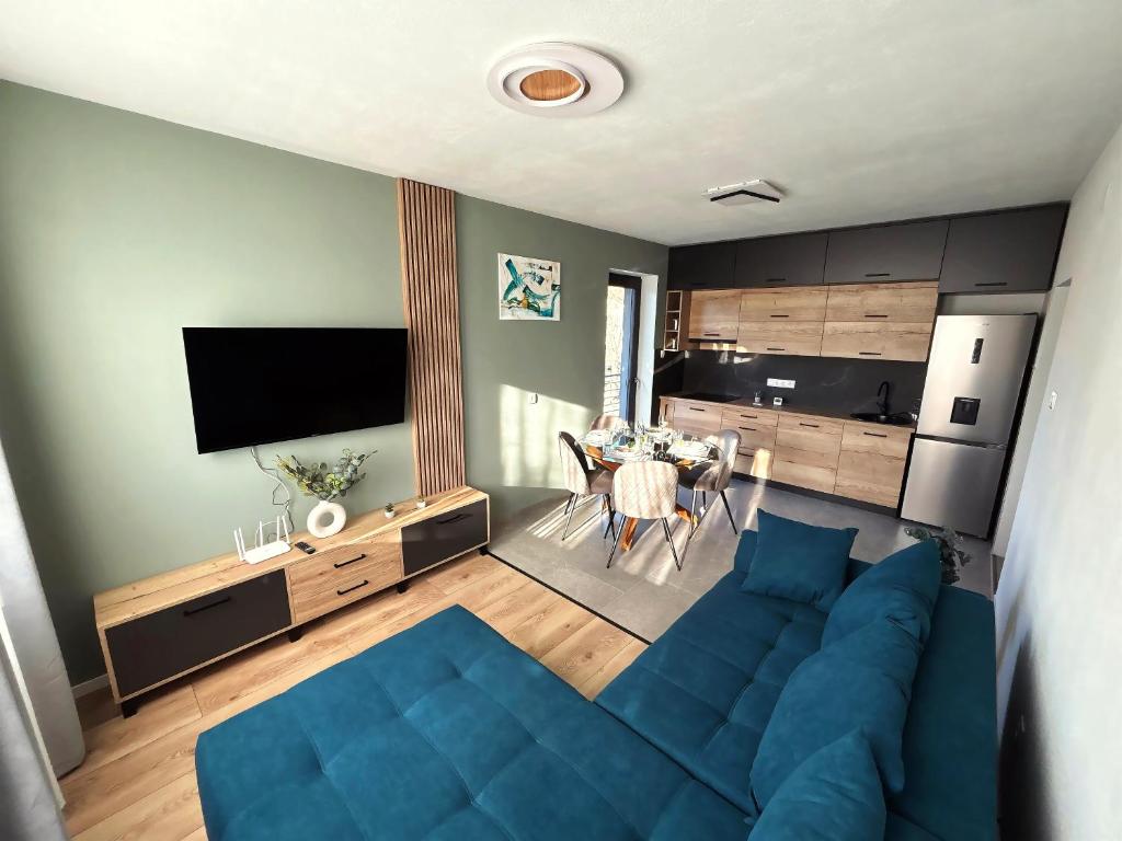 a living room with a blue couch and a table at Forest Lux Apartman in Odorheiu Secuiesc