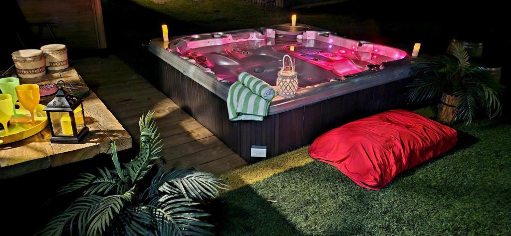a hot tub with a red pillow next to a table at Domaine pour 21 pers avec SPA et GRANGE Festive in Saint-Justin