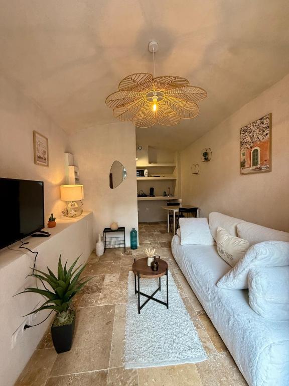 Una sala de estar con un sofá blanco y un televisor. en La Douceur du Fort - Parking, extérieur, vue, en Mercury