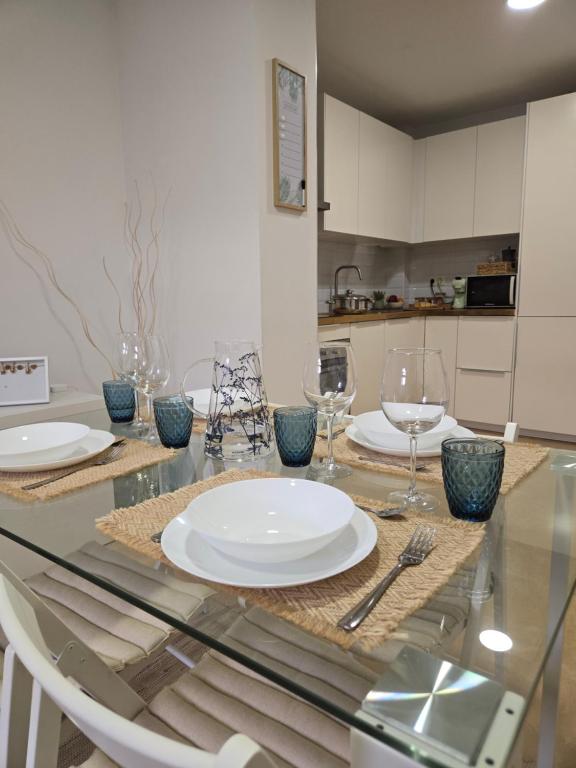 a dining table with plates and wine glasses on it at Ático Formoso in Cee
