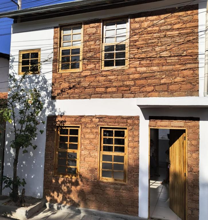 a brick house with yellow windows and a door at Casa de Adobe in Lençóis