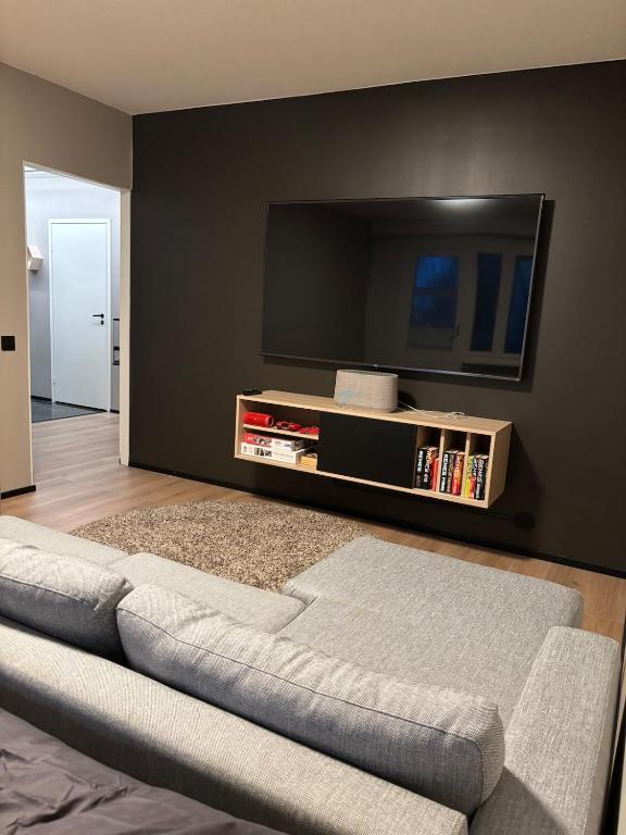 a living room with a couch and a flat screen tv at Stylish and cozy apartment in Rovaniemi