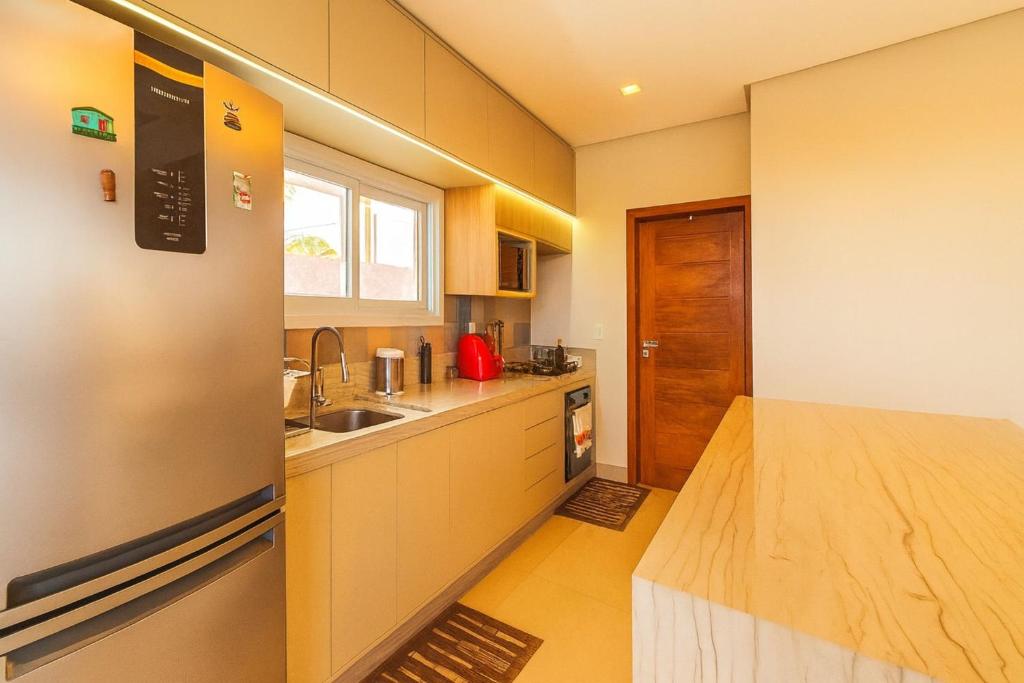 塞古罗港Casa com Piscina e Vista Parcial para o Mar的带水槽和冰箱的厨房