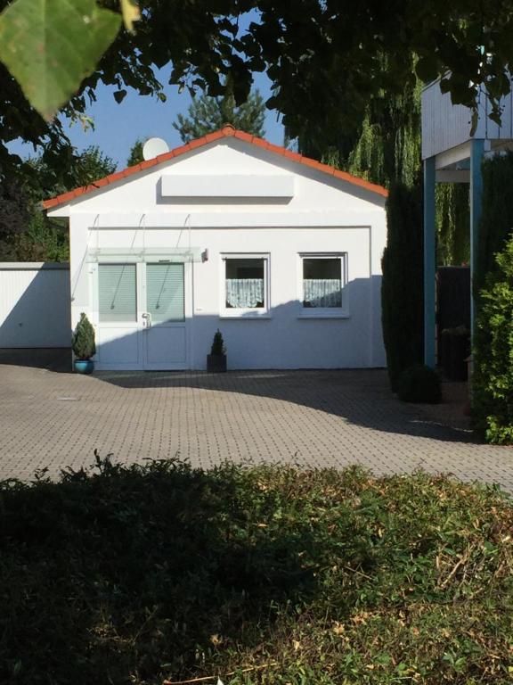 ein weißes Gebäude mit Fenstern und einer Auffahrt in der Unterkunft Ferienhaus Brueckner in Mörstadt