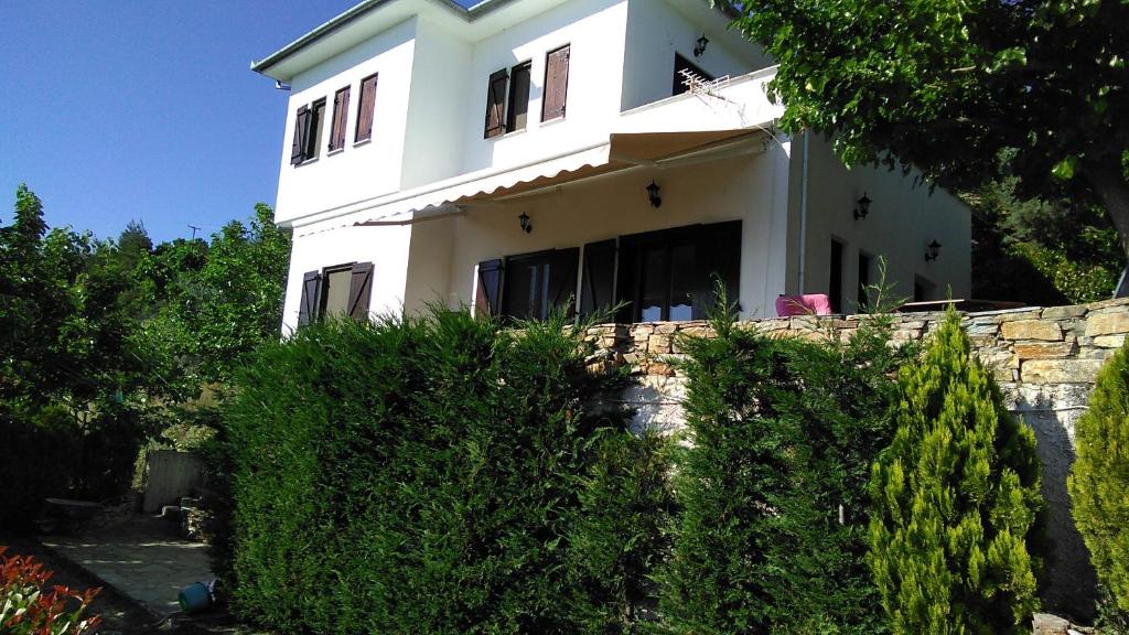 een wit huis op een heuvel met struiken bij Holiday house afetes in Afétai