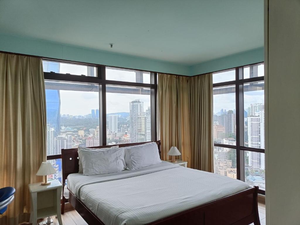 a bedroom with a bed with a large window at Times Square Apartment By Skyline in Kuala Lumpur