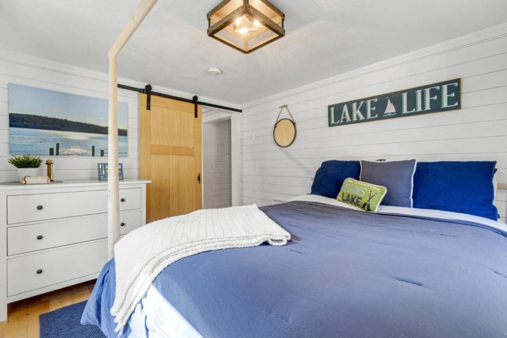 a bedroom with a blue bed with a sign on the wall at Family Cottage, Sandy Beach & Paddleboards in Meredith