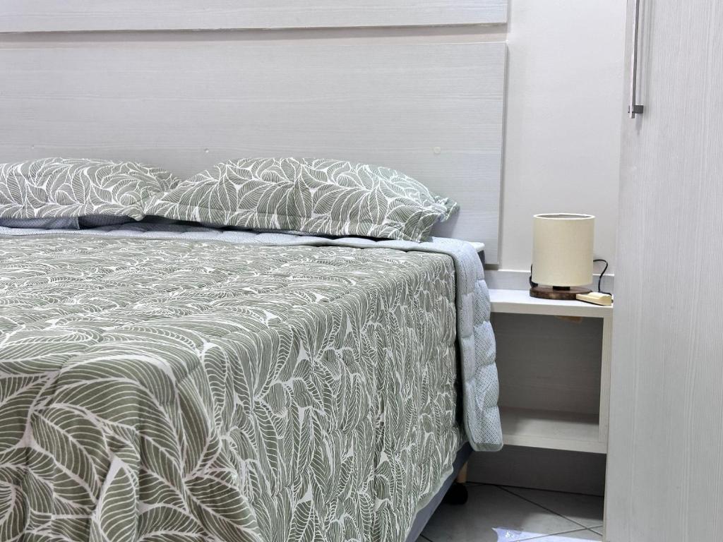 Un dormitorio con una cama con un edredón blanco. en B484 - Apto 3 quartos perto do mar e com vista., en Bombas