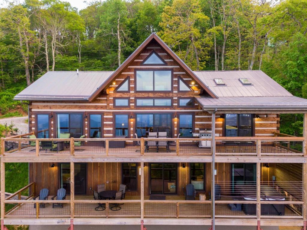 una imagen de una casa de madera con una gran terraza en Above and Beyond, en Boone
