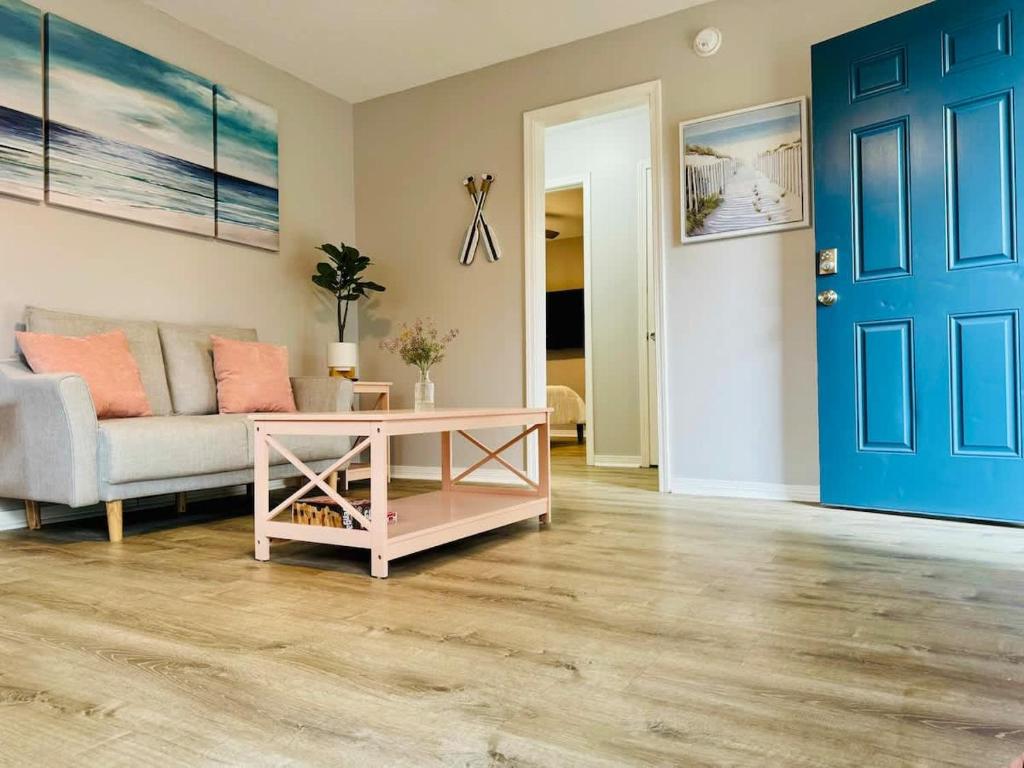 a living room with a couch and a blue door at NEW Getaway by Gulfport Beach in Gulfport