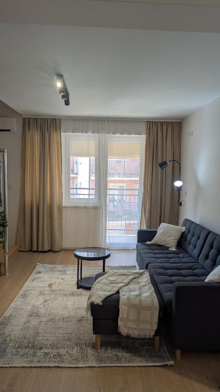 un soggiorno con un divano blu e un tavolo di Staywell a Banja Koviljača