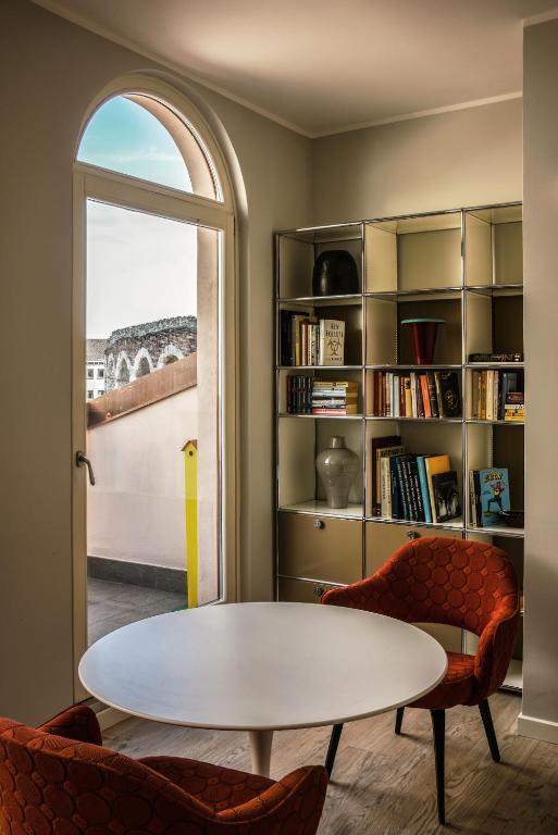 a living room with a table and chairs and a book shelf at Arena's Hospitality in Verona