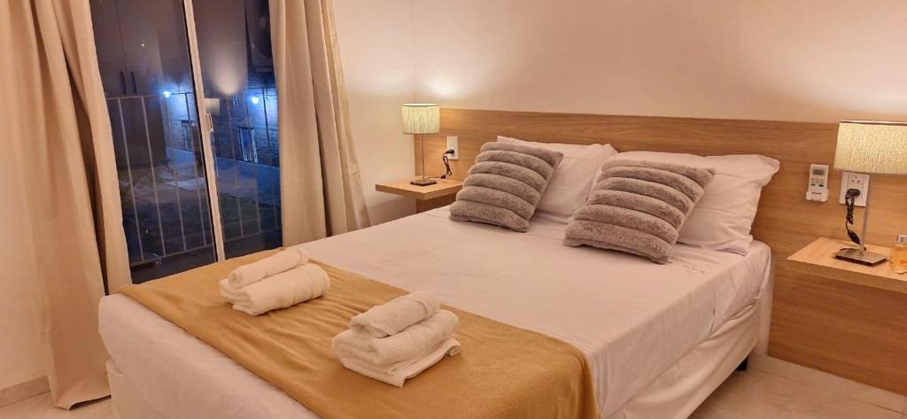 a hotel room with a bed with towels on it at Vela Villa Apart in Villa Ángela