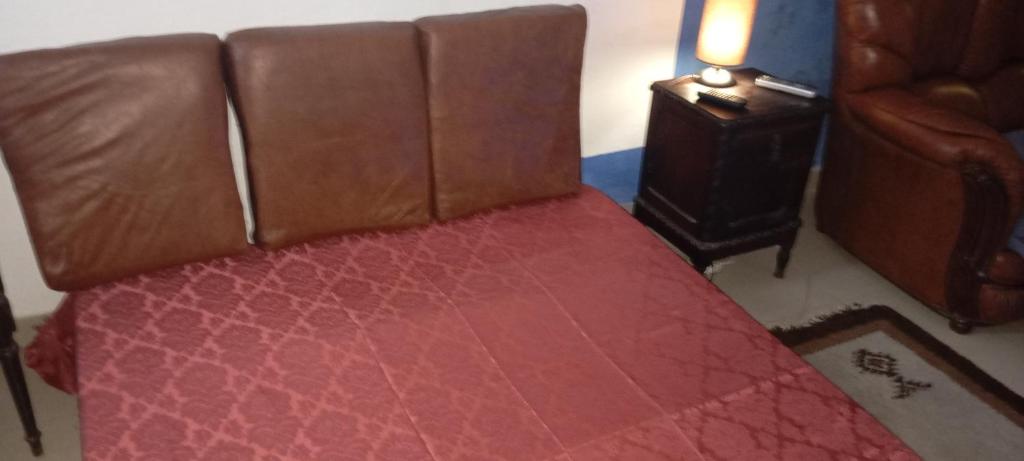 Una cama con asiento de cuero en una habitación. en CiTY CENTER, en Castelo Branco