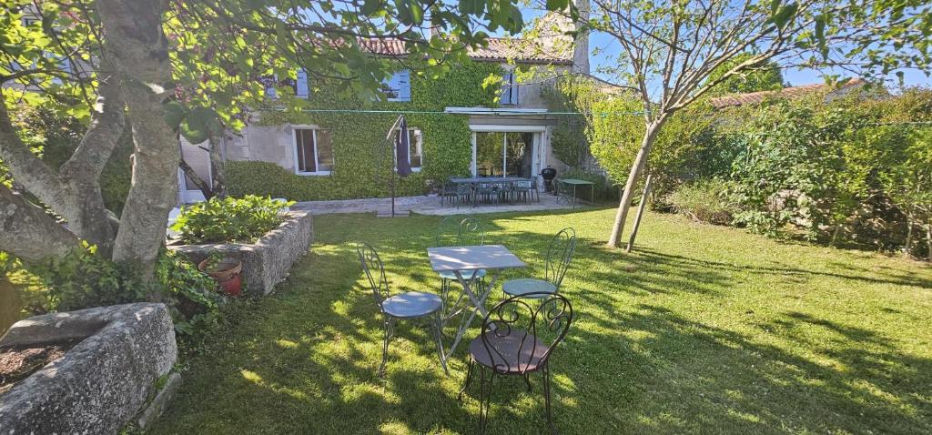 a picnic table in the yard of a house at Maison Charentaise 12 à 14 personnes in Sémussac