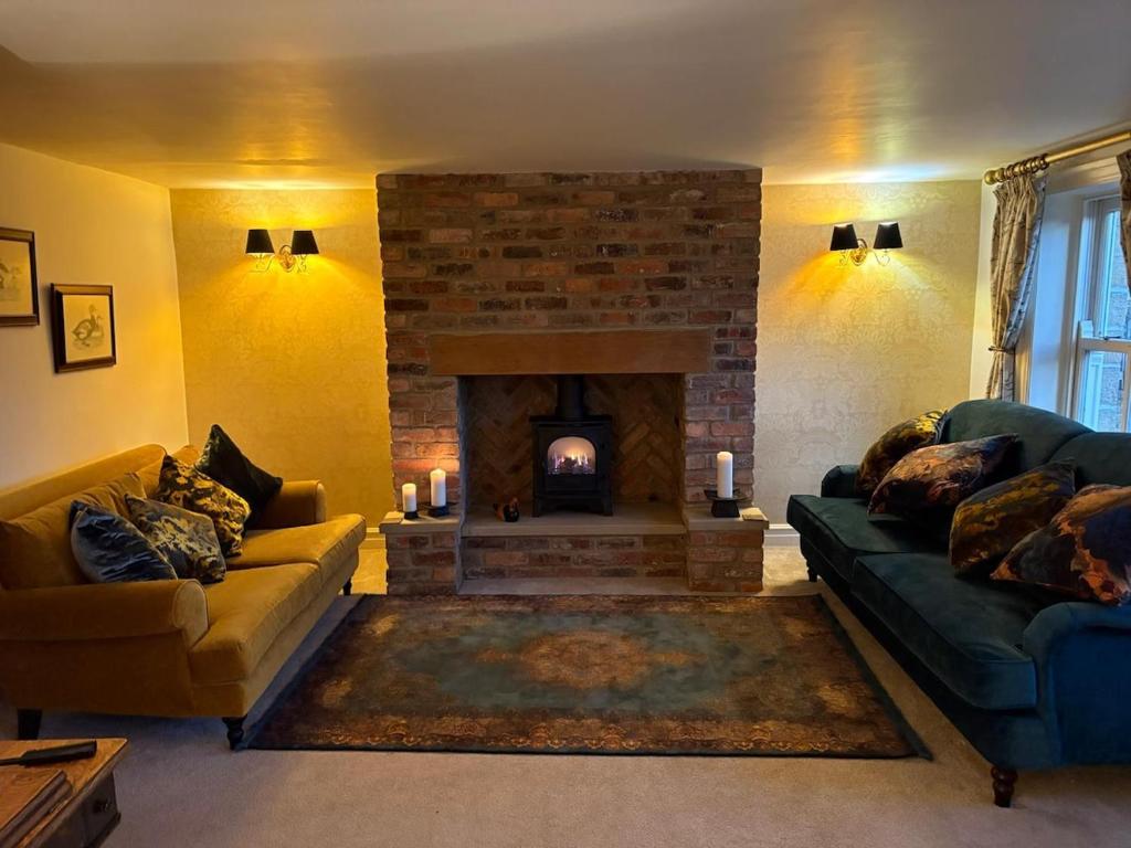 a living room with two couches and a fireplace at Hatters Cottage Eldwick Bingley Yorkshire in Bingley