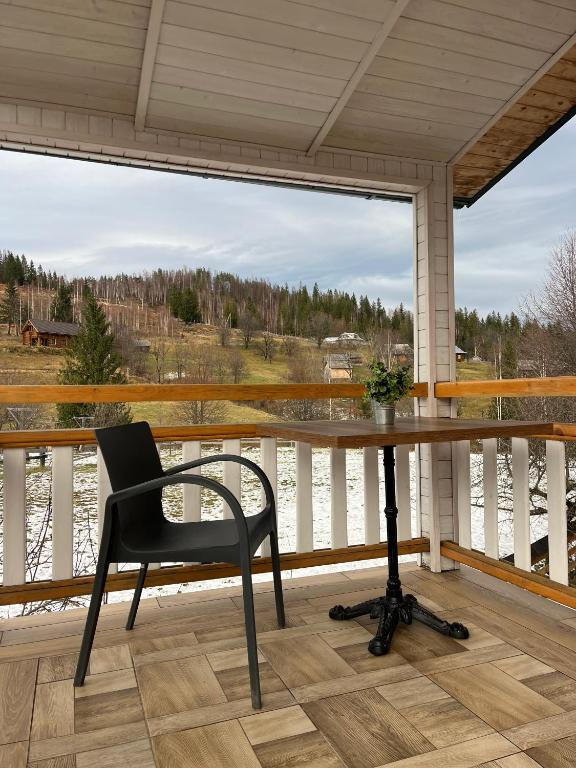 Un escritorio en un porche con una silla y una ventana. en Сироварня Далекі Гори, en Snidavka