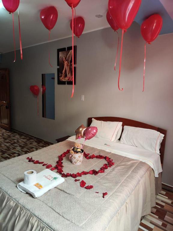 a bed with a heart made out of red balloons at Hotel PRADO'S in Satipo