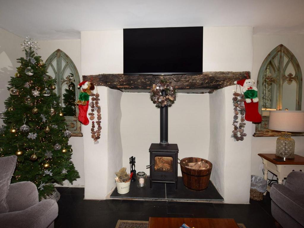 un soggiorno con camino e albero di Natale di 5 Bed in Conwy 48169 a Eglwys-Fâch