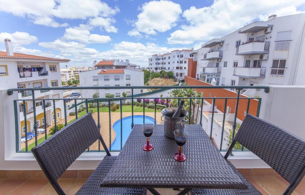 een balkon met een tafel en 2 glazen wijn bij B41 - Windmill Modern with Pool in Lagos