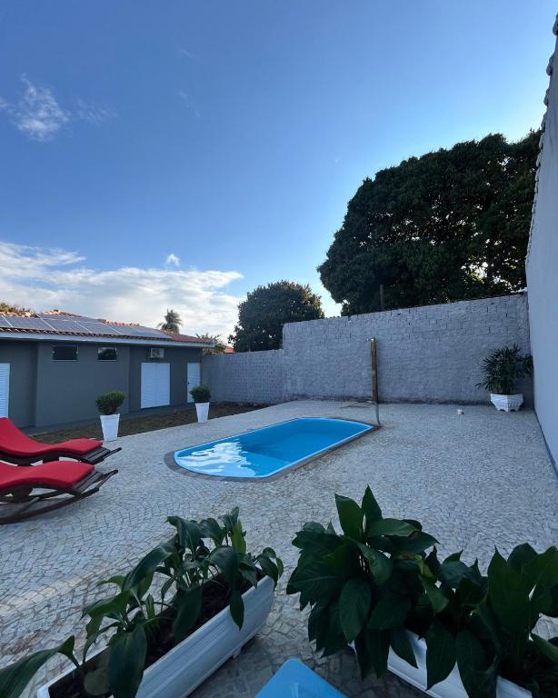 a backyard with a swimming pool and some plants at Suítes Brotas in Brotas