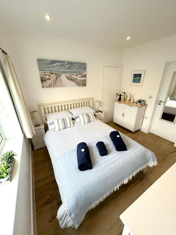 a bedroom with a large bed with blue pillows at Salcombe Bolthole Room in Salcombe