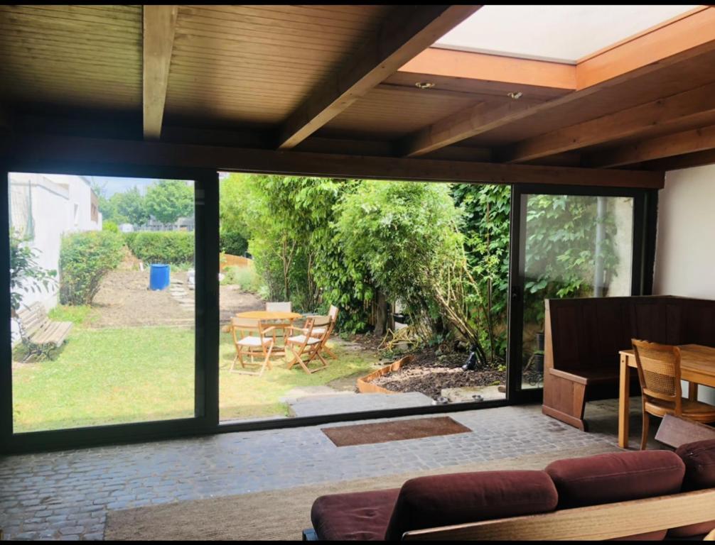 un soggiorno con un divano e una grande finestra di Maison MidCentury chaleureuse proche centre-ville a Strasburgo