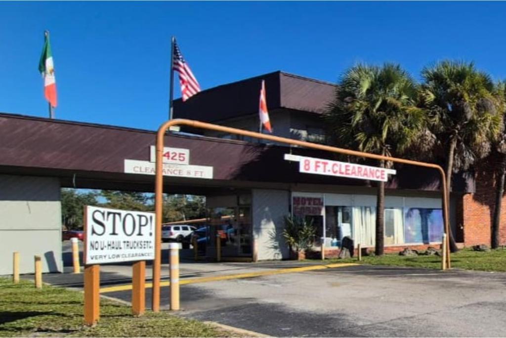 una señal de stop delante de una tienda en Arrow Motel by OYO Near Downtown, en Orlando